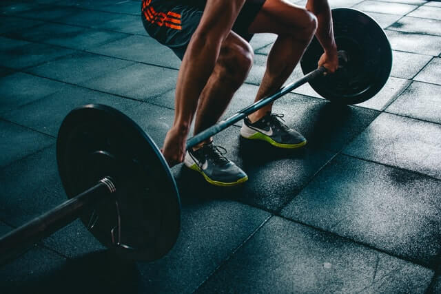 Spor salonu randevu uygulaması. Adam halter kaldırıyor.